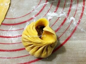 右手食指和拇指提起面皮，像小时候折扇子样一褶一褶把包子皮往中间提起并压紧粘合，同时左手慢慢顺时针转包子，保持右手连续压褶，一般要有15个褶子以上才会比较漂亮，收口粘紧压实