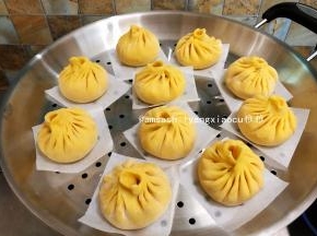 蒸锅此时可以加入水开小火微微加热，让整个锅体以及内部温热湿润，同时把包好的包子底部垫油纸放在蒸上，放的时候要留出空间来，以免发酵的时候包子都挤在一起了，蒸锅关火，盖上锅盖发酵15分钟