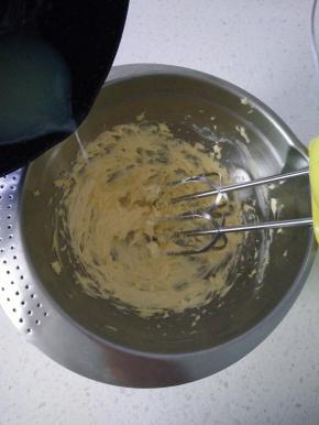 4分次加入煮好的糖水，每加入一次完全吸收再加下次，打到黄油有光泽即可，加入盐搅拌均匀。