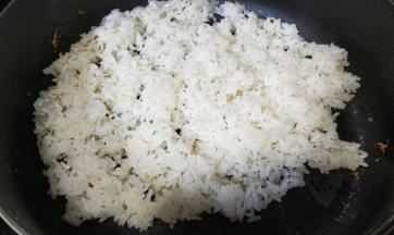 锅裏热油，放入两碗剩米饭、蒜盐炒均匀