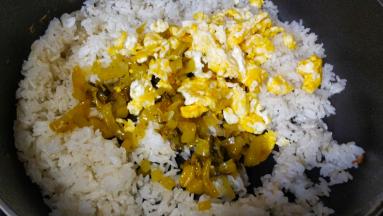 将酸菜和蛋倒入剩米饭裏