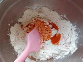 把胡萝卜汁逐次少量加入剩余的面粉中拌匀。