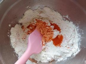 把胡萝卜汁逐次少量加入剩余的面粉中拌匀。