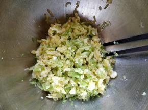 把西葫芦丝浸出的水分挤掉，这样包馅时不会泡烂外皮。和鸡蛋拌匀。