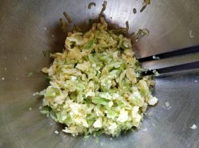 把西葫芦丝浸出的水分挤掉，这样包馅时不会泡烂外皮。和鸡蛋拌匀。