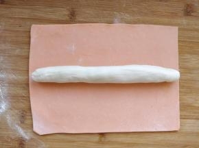 先取一块胡萝卜面团，擀成长方形薄片，把白色面团揉成条，包裹在外面揉匀。这样做出的烧麦皮边缘是橙色，中心是白色，包起来的话更美观。