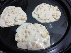 电饼铛中加入适量的油预热，然后用勺子舀一勺玉米面糊倒入锅中摊平