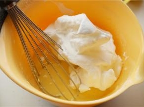 挖三分之一的蛋白霜，加入到蛋黄糊里，翻拌到看不到大块的蛋白。