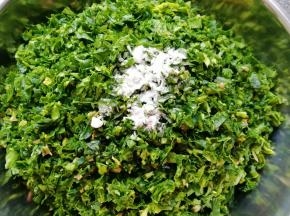 剁好的菠菜放在盆里，加入食用碱搅拌均匀(放食用碱的目的是为了让蒸好的菠菜菜团不发黄，介意的可以不加，不影响口感)。
