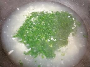 将水淀粉缓缓倒入锅里，一边倒一边用勺子搅拌均匀，下入荠菜碎末搅拌均匀。