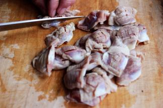 用刀给鸡胗改一下花刀，然后把鸡胗一个分成两瓣。