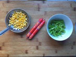 准备好火腿肠，切成片，玉米用水煮熟，青椒切成丝就可以