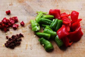 青尖椒和红尖椒用刀切成块，干红椒切丁，准备好花椒。