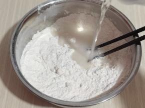 首先将面粉加入大口器具中，酵母粉用温水化开，分次倒入面粉中，一边用筷子搅拌成絮状！