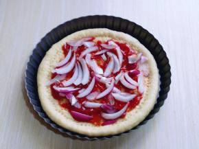 加入披萨酱，抹平，再加入提前切好的洋葱！撒上一层马苏里拉芝士！