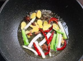 锅烧热倒入适量的油，放入生姜，花椒，干辣椒，八角，桂皮，葱段爆香。