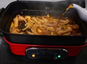 加入鸡爪翻炒2分钟、加料酒入锅。