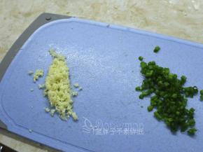 在吐司晾凉期间，我们来准备蒜泥。先将蒜头切成细细的颗粒，越细越好。香葱切成葱花。