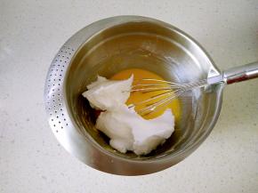 7取三分之一蛋白霜加入蛋黄糊，用手动打蛋期捞底翻起，一边转动打蛋盆，重复动作。