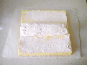 14把剩下的奶油涂满橘子的缝隙，提起两端油纸向中间卷，卷成O形包上油纸，放冰箱冷藏一小时定型。