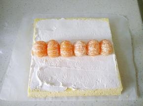 13蛋糕两端各斜切一刀，在蛋糕抹上一层奶油，摆入去皮的橘子。