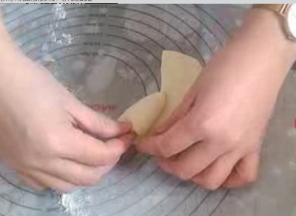沿切开半径绕圆心卷起，直至两条半径重合。捏紧接口呈现桃形。