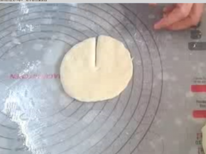 取其中一份，压扁，排气，擀成圆片。直径大约拇指与食指张开的距离。沿圆形片半径切开。