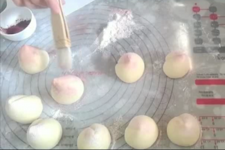 用羊毛刷点红曲粉在桃尖处轻点，然后在其它部位刷上高粉。