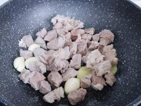 再加入焯水的牛肉煸炒，将牛肉水分炒干。
