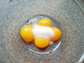 给蛋黄里面加入10g的细砂糖，用手动打蛋器搅打均匀。