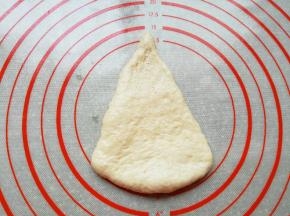 取一份面团整理擀成三角形。