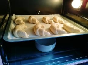 烤箱调至“发酵”功能，放一碗热水，放入羊角包生胚发酵30分钟。