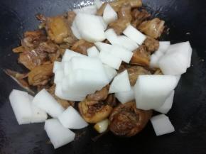 在把萝卜块放入，翻炒一分钟左古