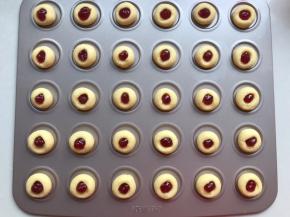 6．	果酱装入裱花袋中，最好揉搓一下，把果粒揉开，也可以用料理机打一下，这样挤的时候不会堵住裱花袋。剪一个小口，挤在小窝中。