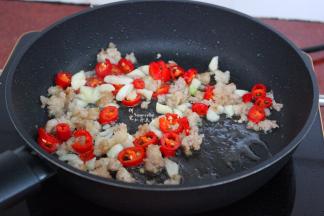 热锅，倒油，放入剁碎的肉末、大蒜、生姜，煸炒出猪油出来，然后放入辣椒炒出辣味，出锅。