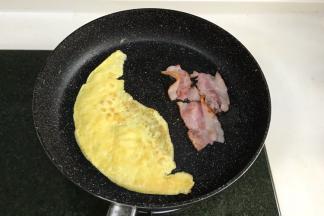 把剩下的蛋黄液和蛋白一起搅打均匀，然后放入煎锅中煎熟，把培根也入锅煎一煎。