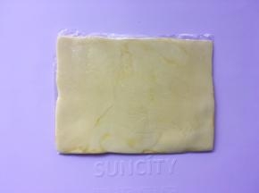 之后对折保鲜袋，将黄油用擀面杖擀成均匀厚度的黄油片，之后入冰箱冷冻10分钟将黄片冻硬  