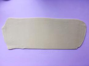 多撒点干粉，将折叠好的面片擀成宽20厘米，长45厘米左右的长方形 