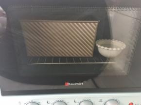 烤箱启动发酵键，烤箱内放碗热水，将模具放入烤箱内二次发酵
