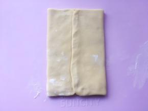 将两侧的面片向中间对折，包裹上黄油片，封口处捏紧