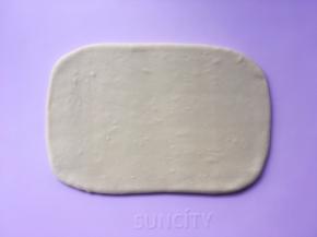 揉面垫上撒适量的干粉，将揉好的面团擀成小号保鲜膜大小的长方形 ，包裹上油纸，装入保鲜袋入冰箱冷冻 