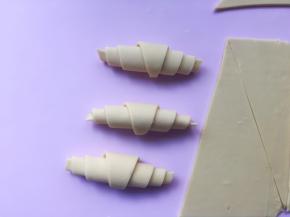 裁好的面片，从宽的一头轻轻将面片卷起，卷的时候一定要轻，这样面团才会没有阻力的膨胀 