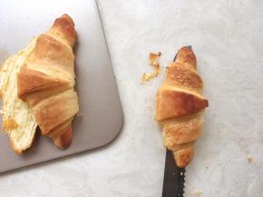 面包出炉降温，凉透后用锯齿刀将牛角包横切开  