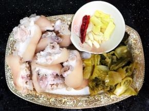 猪手焯水备用，酸菜切片。准备辅料：姜片、蒜头、辣椒米。