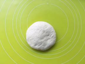 取出发酵好的面团，放在揉面垫上按压排气，之后松弛10分钟
