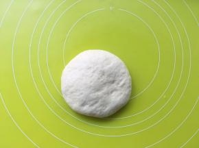 取出发酵好的面团，放在揉面垫上按压排气，之后松弛10分钟
