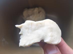 加牛奶启动揉面程序将材料揉成面团，揉好的面团切开，横切面面团紧实，孔洞很少
