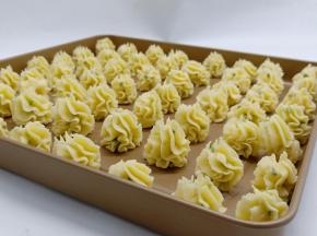 准备一个不粘烤盘、将曲奇有间隔地挤在烤盘上。