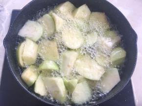 筷子夹茄子块入油锅内炸