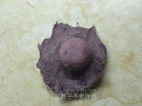 取一个面团，压扁之后在面团中间放上芋泥馅。